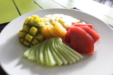 Restoran menü. Ananas, karpuz ve portakal salatası, karışık meyve. Bir restoranda tablo ayarı.