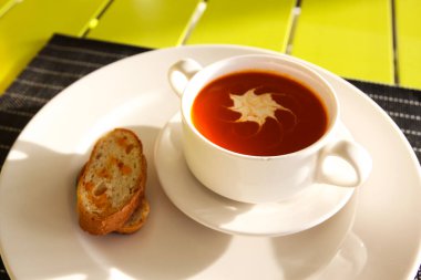 Domates suyu bir fincan ve ekmek. Bir restoranda tablo ayarı