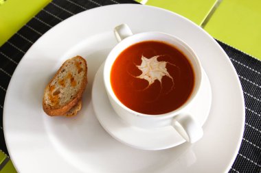 Domates suyu bir fincan ve ekmek. Bir restoranda tablo ayarı