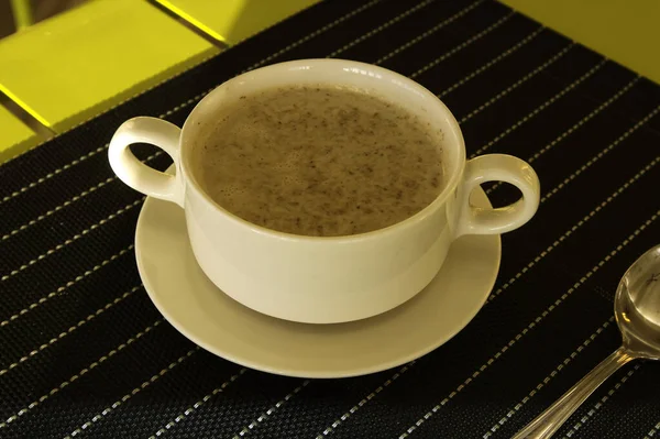 Soup in a cup on the table. Table setting in a restaurant.