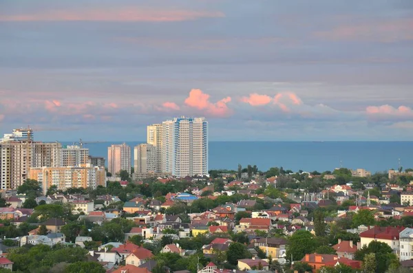 Karadeniz kıyısında kar beyazı, yüksek katlı bir bina. Suyun masmavi rengi ağırlıksızlığı vurguluyor, bina havada süzülüyor gibi görünüyor..