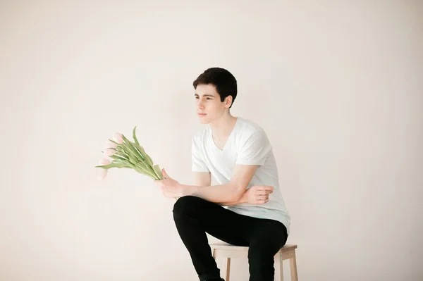 Handsome young man with pink tulips — Stock Fotó
