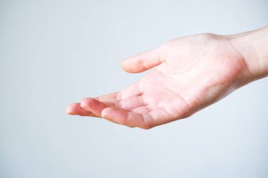 Bir kadının elini aç, avuç içi gri arka planda yalıtılmış..