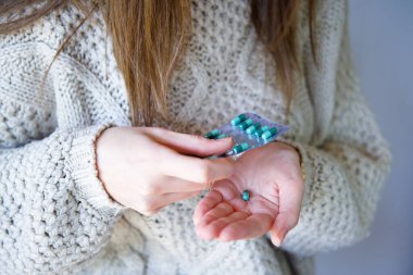 Kadının açık eliyle hap aldığı yakın plan..