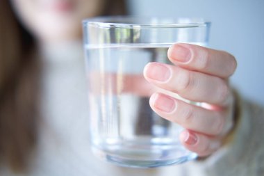 Kadın temiz su bardağını kameraya uzatıyor..