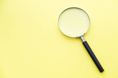 Sarı arkaplanda büyüteç.