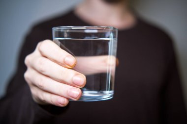 Adam kameraya temiz su bardağını uzatıyor..