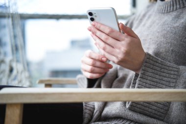 Telefonu kullanan genç bir kadının yakın çekimi..