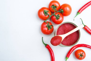 Yeşil arka planda kırmızı biberli konserve domates ezmesi..