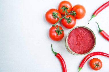 Yeşil arka planda kırmızı biberli konserve domates ezmesi..