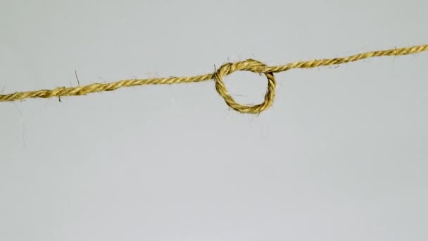 在浅灰的背景下 一个简单的结紧固在麻绳上 — 图库视频影像