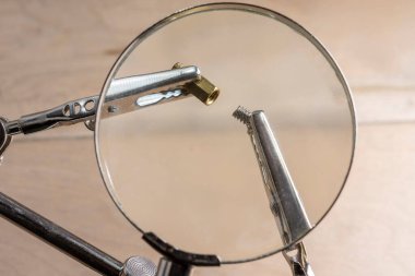 Bilgisayar vidaları büyüteç altında klipslerle tutulur