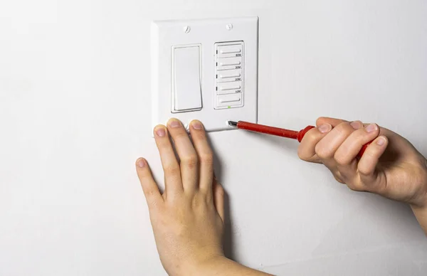 Technician tightens the last screw on the fan timer and  light switch