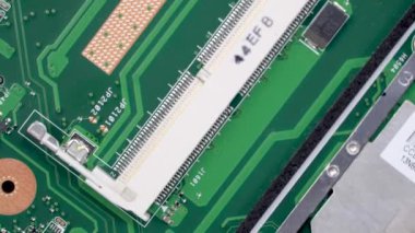 Laptop ana kartı beyaz plastik bir stantta saat yönünde dönüyor.