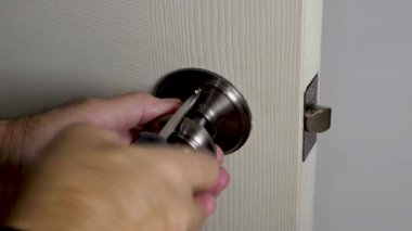 Önce, eski kilidin yuvarlak top kulplarını kapıdan çıkarman gerekiyor.