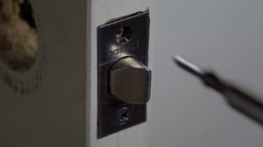 Önce, iki vidayı sökerek kapının mandalını çıkar.