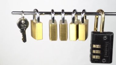 Küçük bronz kilitler ve anahtarlar metal bir çubukta asılı ve sallanıyor.