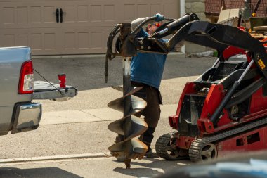 Ağaç dikmek için zemine delik açmak için hidrolikleri büyük bir matkapla bağlıyoruz.