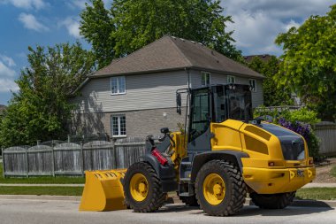 Yeni sarı traktör evin önünde durdu.