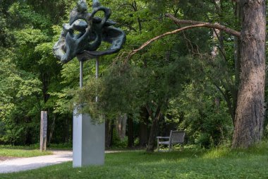 Eski parka girişte büyük bir ağacın altında tabelalar ve bir bank vardı.