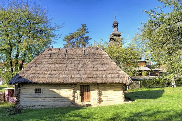 Старый дом - плести и плести рядом с церковью — стоковое фото