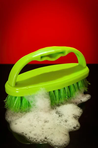 Green brush with soap suds — Stock Photo, Image