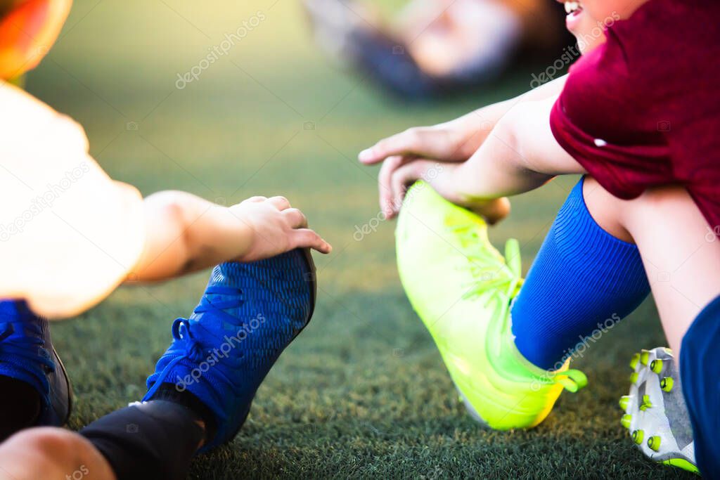 Selective focus to soccer players are stretching their hands to catch their feet to warming up and stretching the body and foot before the competition or practicing.