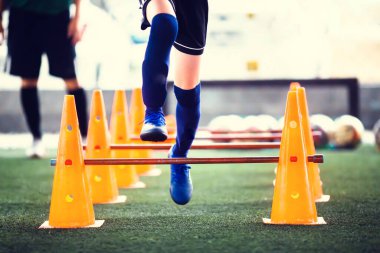 Bulanık çocuk futbolcuyla külahları ayırmak ve engelleri aşmak için seçici bir odaklanma. Çocuk futbol antrenmanı.