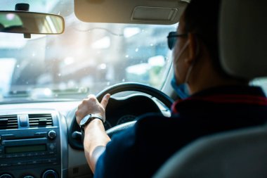 Adam sabahın köründe seçici bir dikkatle araba sürüyor..