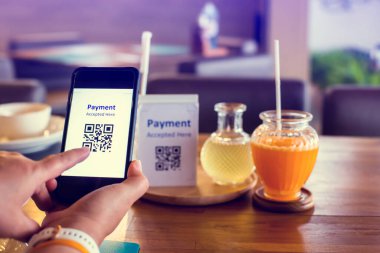 Hand 'e odaklanmak için akıllı telefonu kullanarak etiketteki QR kodunu bulanık limon otu suyu ve portakal suyu ile tarayın ve para almadan dijital ödeme yapmayı kabul edin. Qr kod ödeme kavramı.