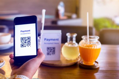 Hand 'e odaklanmak için akıllı telefonu kullanarak etiketteki QR kodunu bulanık limon otu suyu ve portakal suyu ile tarayın ve para almadan dijital ödeme yapmayı kabul edin. Qr kod ödeme kavramı.