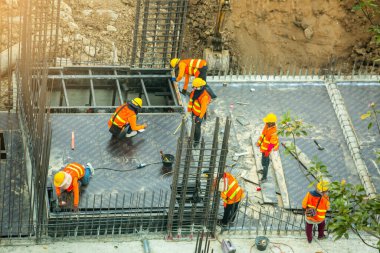 Bangkok Tayland 18 Haziran 2021: İnşaat işçileri inşaat alanında beton zemin hazırlamak için çelik yapılar üzerinde çalışıyorlar. Büyük ölçekli yüksek ölçekli inşaat projesi.