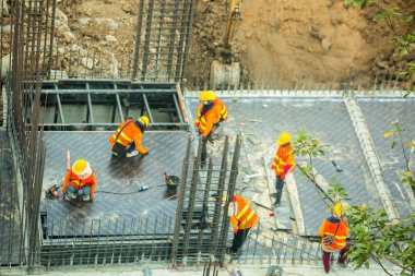 Bangkok Tayland 18 Haziran 2021: İnşaat işçileri inşaat alanında beton zemin hazırlamak için çelik yapılar üzerinde çalışıyorlar. Büyük ölçekli yüksek ölçekli inşaat projesi.