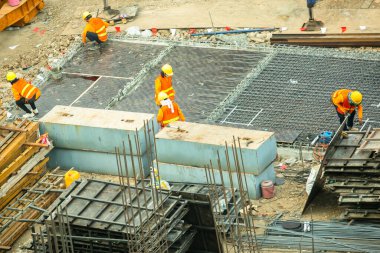 Bangkok Tayland 18 Haziran 2021: İnşaat işçileri inşaat alanında beton zemin hazırlamak için çelik yapılar üzerinde çalışıyorlar. Büyük ölçekli yüksek ölçekli inşaat projesi.