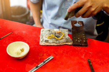 Kuyumcuya seçici odak noktası, altın mücevherleri tamir etmek için gaz gücü kullanmak..