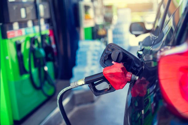 Benzin istasyonundaki bulanık yakıt kutusuyla eski kırmızı yakıt hortumuna seçici bir odak. Benzin istasyonunda yakıt doldur..