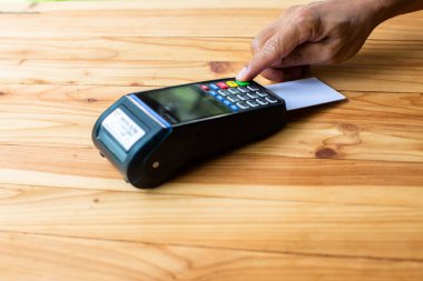 Hand 'in seçici odak noktası kredi kartını kredi kartı okuyucu, kredi kartı ödemesi, ürün ve hizmet satın alma ve satışı, nakit olmadan ödeme kavramına koydu..