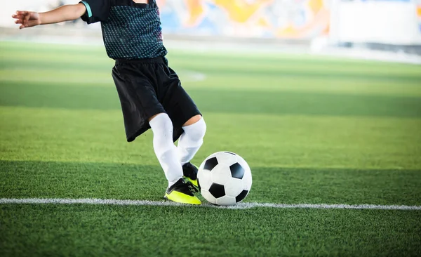 有选择性地专注于足球与运动模糊的儿童足球运动员在人造草皮上拍摄它 足球比赛的足球运动员训练 — 图库照片