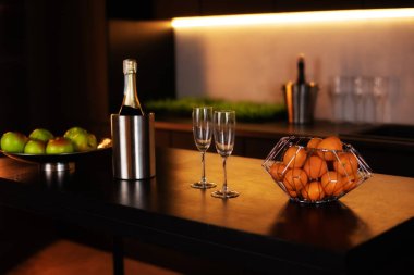 Mutfak mutfağı. Çatı katı tarzı koyu renkli bir adası var. Mutfak adasında şampanya şişesi ve buzlu şampanya. Kutlama konsepti Sevgililer Günü