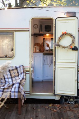 Karavanda farklı mutfak aletleri var. Kamp tatili. Kamp aracının içinde. Karavanda kamp yapmak, karavan mutfağı. Kapısı açık bir karavan evi. Tekerlekli mutfak gereçleri. Campervan. 