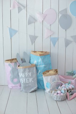 Bahar evi dekorasyonu ve Paskalya dekorasyonu. Paskalya odasının içi çok renkli. Bir sürü renkli Paskalya yumurtası ve havuç dolu sepetler! Tahta beyaz duvarda bayrak var. Paskalya tarzında çocuk odası.