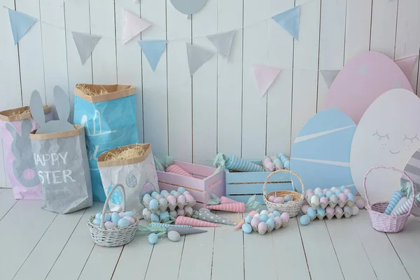 Paskalya odasının içi çok renkli. Bir sürü renkli Paskalya yumurtası ve havuç dolu sepetler! Bahar evi dekorasyonu ve Paskalya dekorasyonu. Tahta beyaz duvarda bayrak var. Paskalya tarzında çocuk odası.