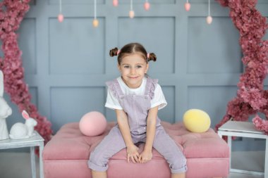 Güzel küçük kız renkli paskalya yumurtalarıyla oynuyor. Aile tatilleri, gelenekler. Hasat, küçük çiftçi. Paskalya yumurtası avla. Çocuk oturma odasında oyuncaklarla oynuyor. Çocuk Paskalya yumurtalarının peşinde..