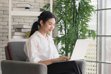 Genç Asyalı kadınlar internette çalışmak, evden çalışmak ve koronavirüs salgını sırasında internetten alışveriş yapmak için dizüstü bilgisayar kullanıyorlar..