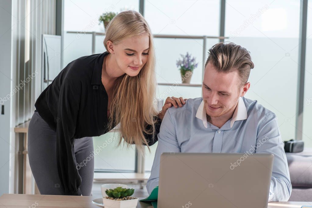 Young business man and woman working from home-office with morning sunshine. They are communicating in social network and searching information online.