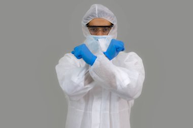 Erkek doktor, araştırmacı, göz koruyucu gözlük takan bilim adamı gri arka planda eldiven ve maske takıyor. Sağlık ve Tıp Konsepti.