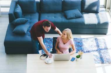 Genç iş adamı ve kadın sabah güneşiyle ev ofisinden çalışıyorlar. Sosyal ağda iletişim kuruyorlar ve çevrimiçi bilgi arıyorlar.