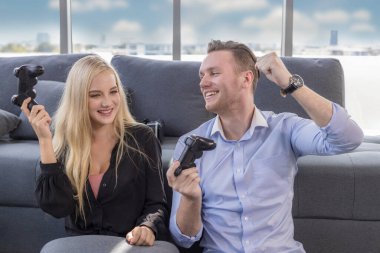 Evde yerde oturan genç bir çift. Karı ve kocanın portresi bir joystick ile video oyunları oynarken eğleniyor. Evde kal..