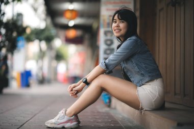 Uzun saçlı güzel Asyalı kadın Tayland 'daki Yaowarat Çin Mahallesi' ndeki festivale gidiyor. Gece gezgin kadının sokak fotoğrafçılığı.