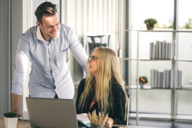 Genç iş adamı ve kadın sabah güneşiyle ev ofisinden çalışıyorlar. Sosyal ağda iletişim kuruyorlar ve çevrimiçi bilgi arıyorlar.